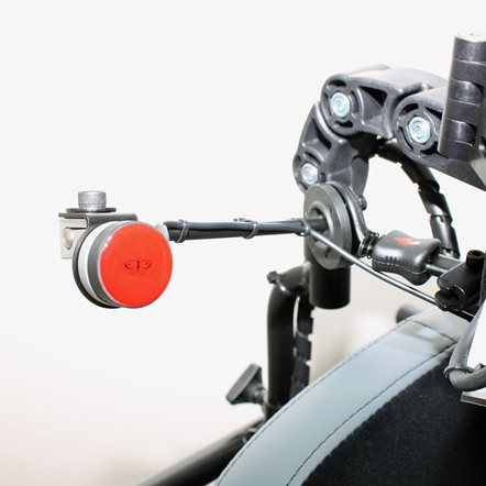 Close up of a piko button mounted onto a power wheelchair headrest.