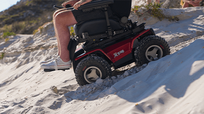 A man driving an off-road, all-terrain powered wheelchair.