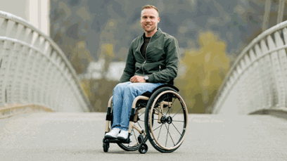 A man propelling a QUICKIE Nitrum ultra-lightweight rigid wheelchair.